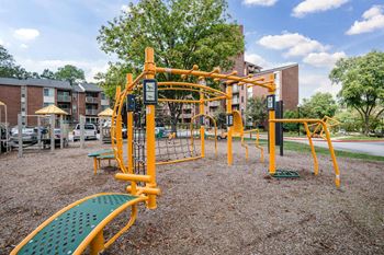 A playground with a yellow and green slide and a yellow and green climbing structure.at Aspen at Lake Trail, Columbia, 21045